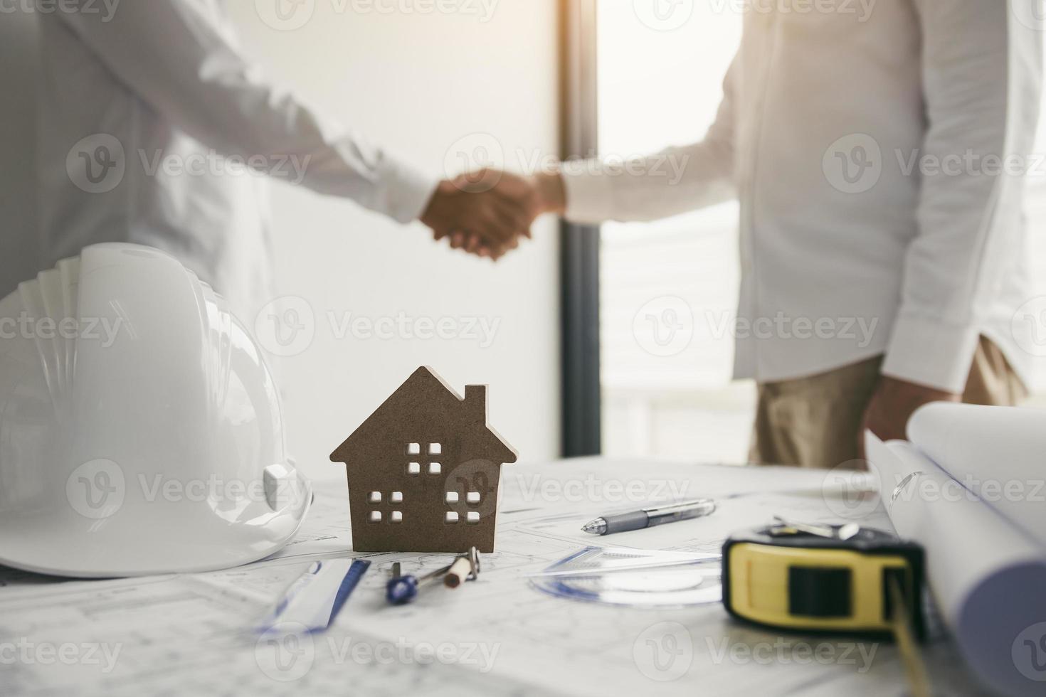 deux ingénieurs avec un ouvrier du bâtiment saluant un contremaître lors de la rénovation d'un appartement. photo