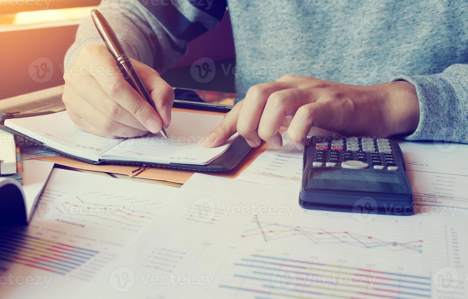 jeune homme faisant des finances au bureau à domicile avec calcul du coût. photo