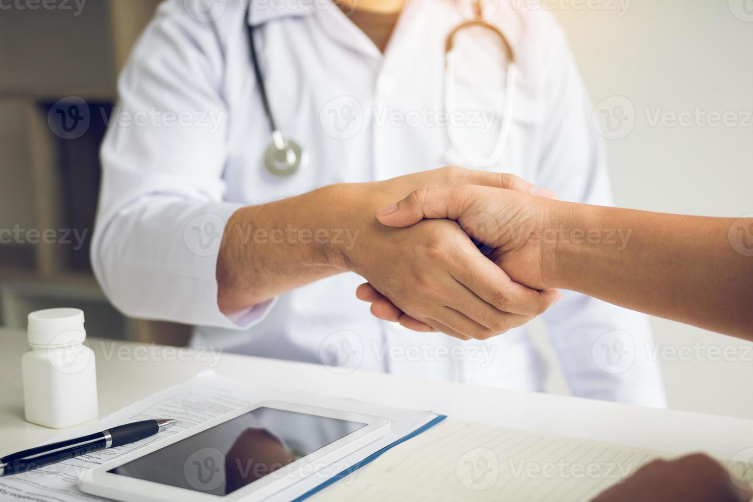 médecin serrant la main d'un patient plus âgé dans la salle de la clinique. photo