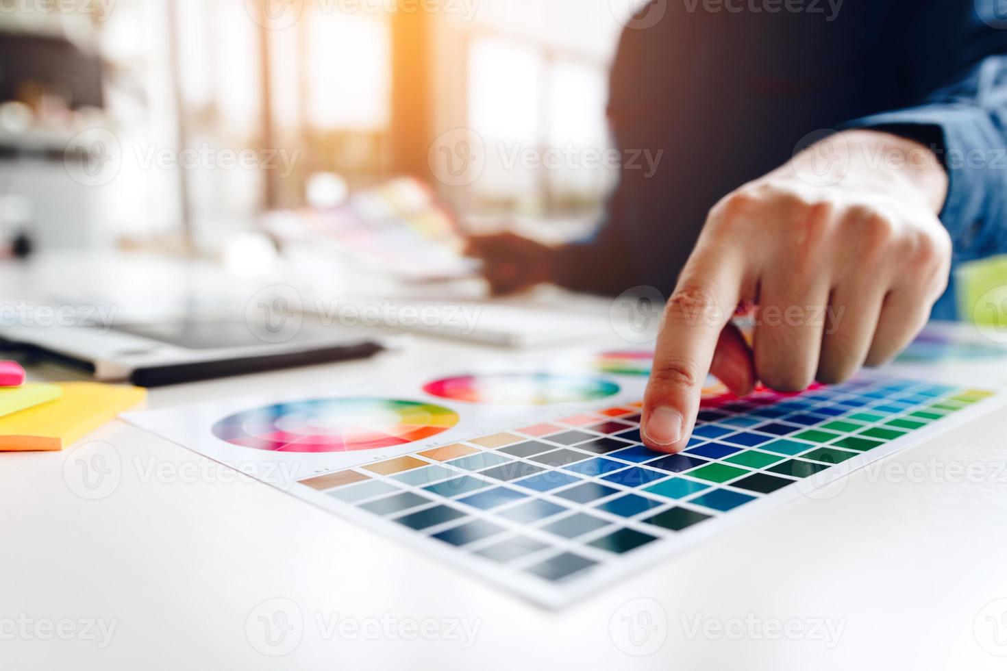 designers créatifs indépendants travaillant sur un bureau à l'aide d'une tablette graphique numérique et dessinant avec un stylo dans un bureau à domicile moderne. photo