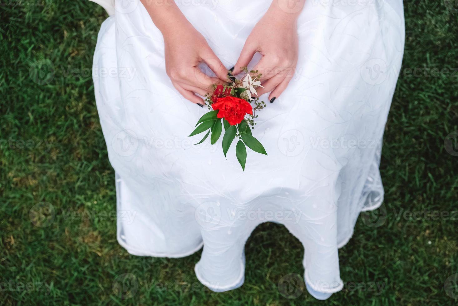 boutonnière pour mariage entre les mains d'une jeune fille mariée en robe blanche. copie, espace vide pour le texte photo