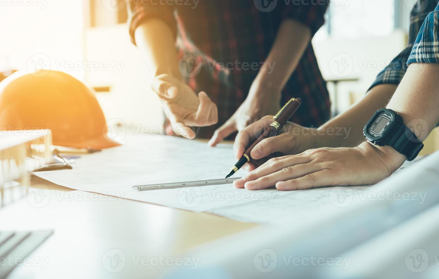 architectes travaillant avec des plans et discutant ensemble du projet lors de la réunion au bureau. photo