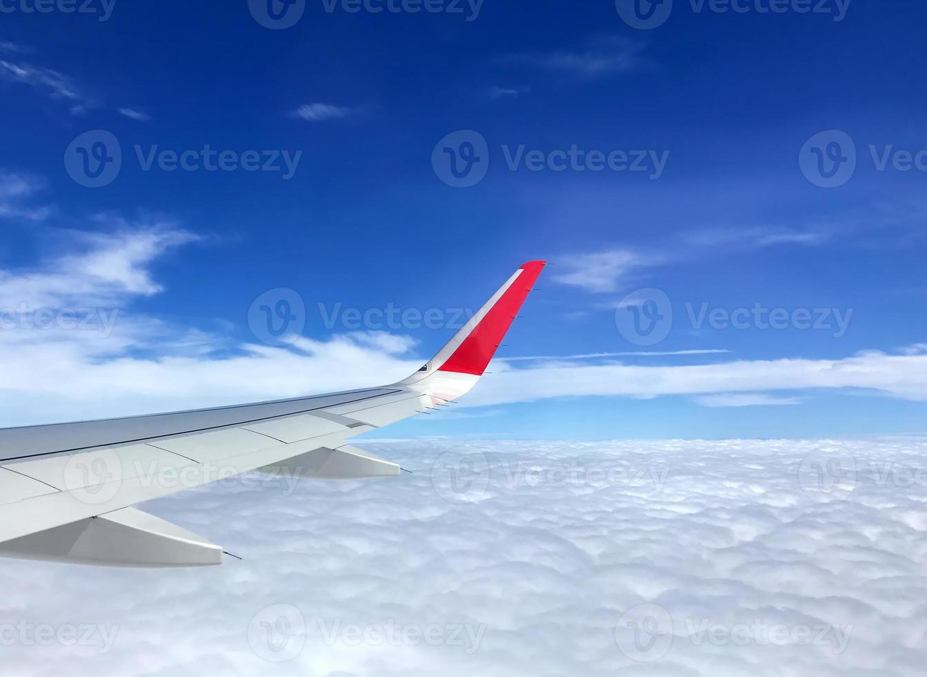 concept de voyage, vue sur les nuages depuis la fenêtre de l'avion avec plus de nuages et de ciel bleu. photo