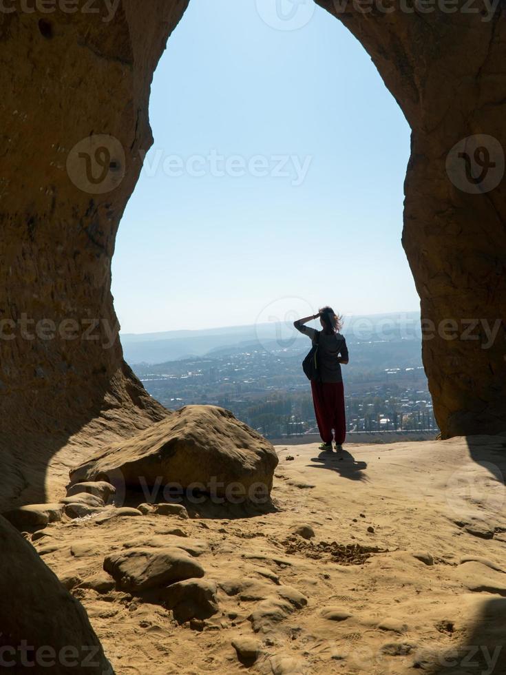 fille touristique debout avec son dos sur une montagne de sable et regardant au loin par une journée d'automne ensoleillée photo