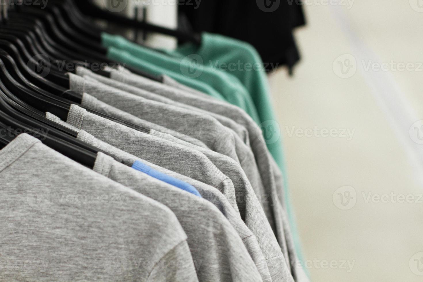 quelques vêtements usagés accrochés à un rack dans un marché aux puces. fond de robe. mise au point sélective. photo