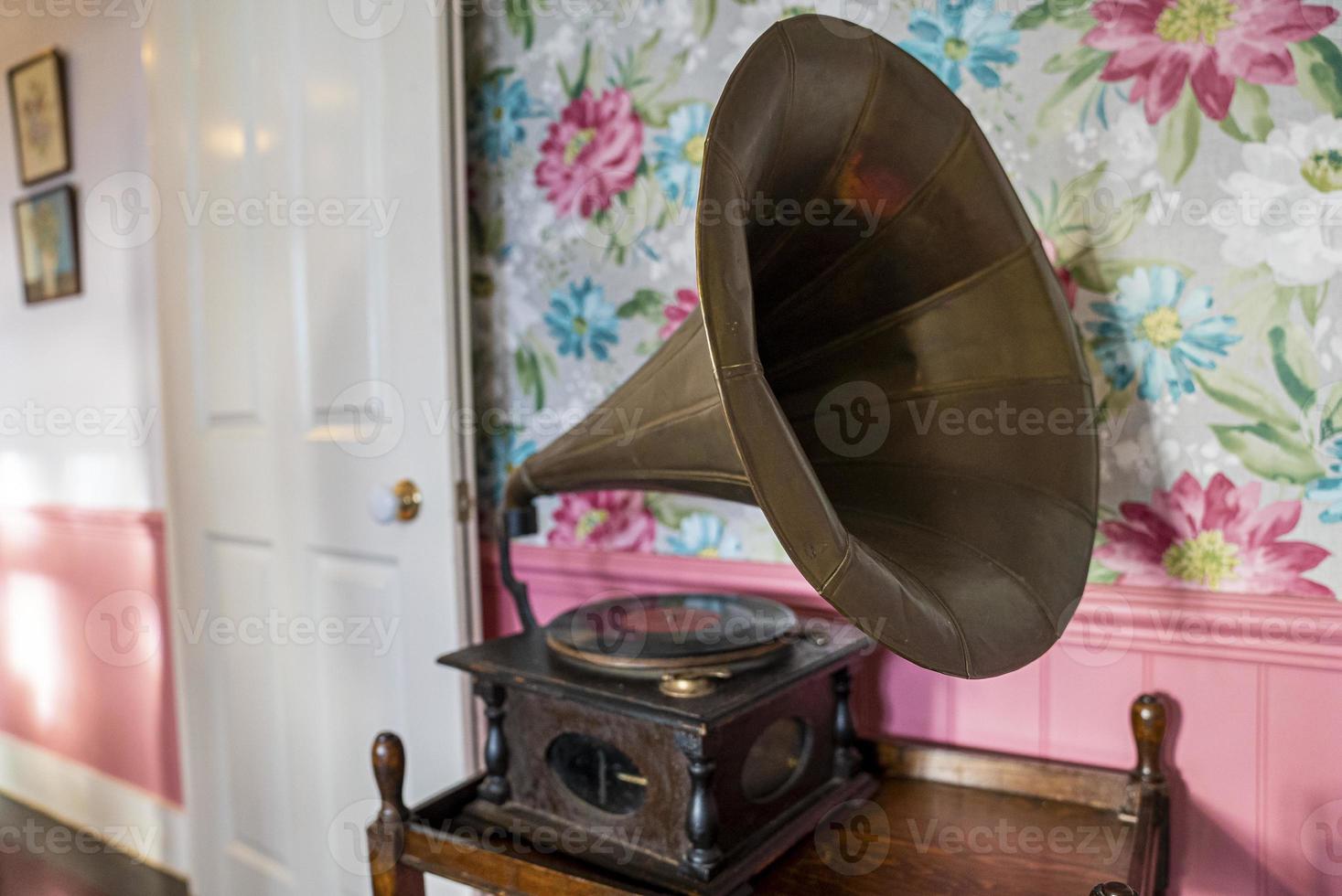 Gramophone en laiton antique avec haut-parleur à pavillon sur table contre un mur de décoration photo