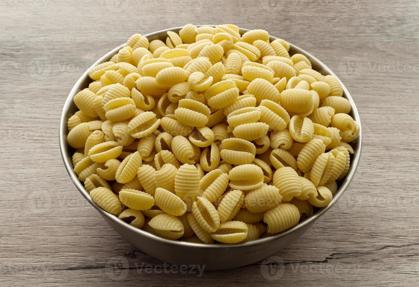 pâtes italiennes crues gnocchetti sardi sur table en bois. photo