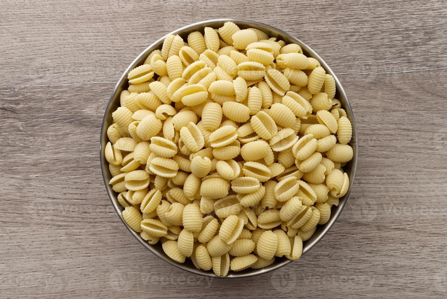 pâtes italiennes crues gnocchetti sardi sur table en bois. vue de dessus. photo