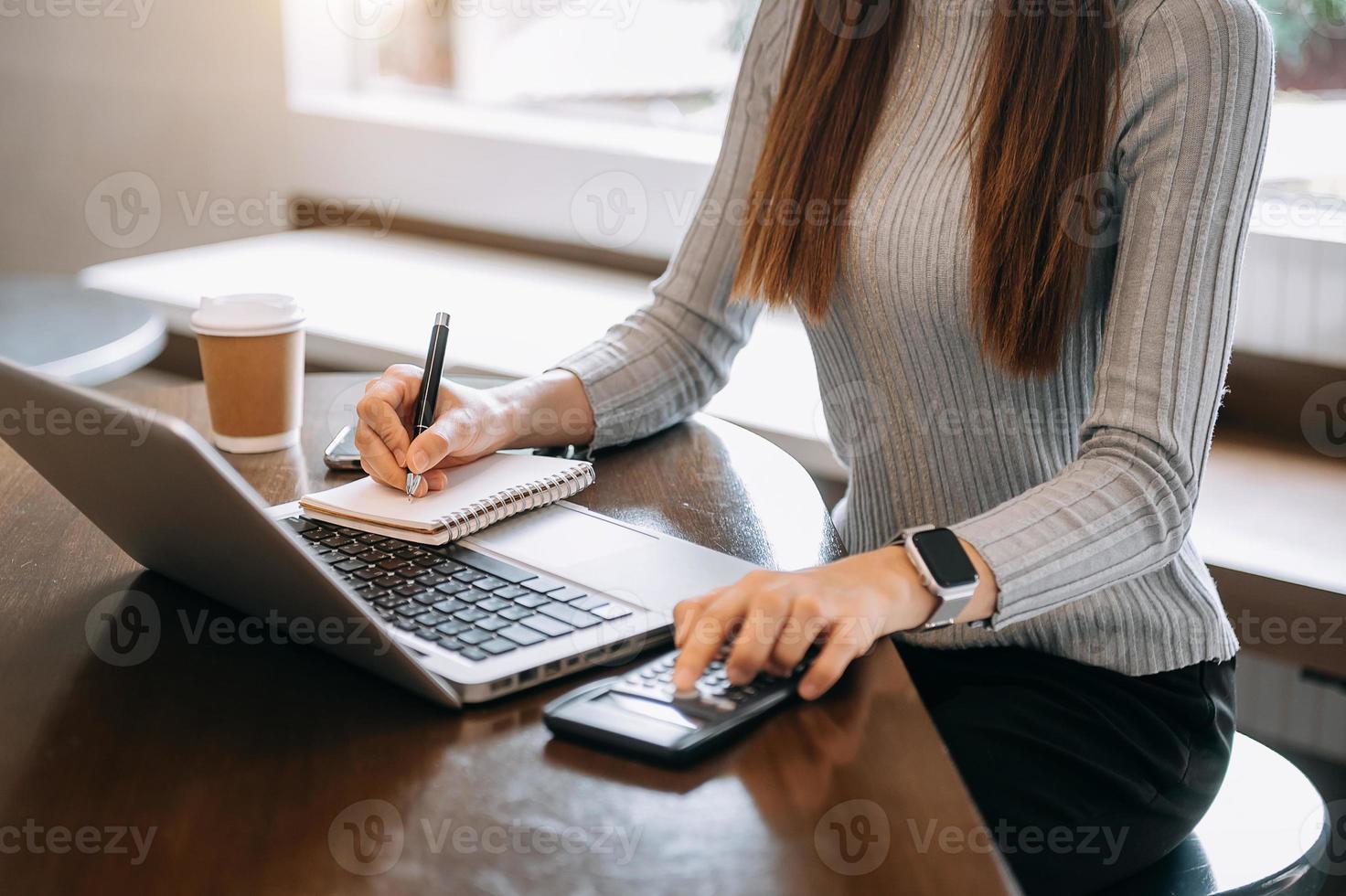 homme de main faisant des finances et sur le bureau au sujet des coûts au bureau. photo