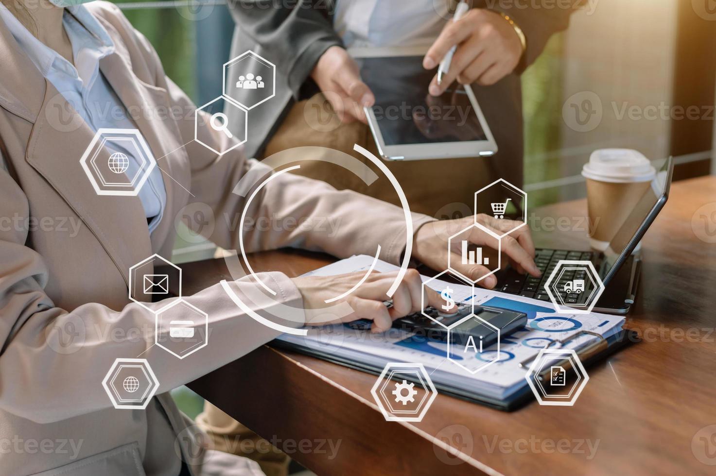 main de femme d'affaires travaillant avec un ordinateur portable, une tablette et un téléphone intelligent au bureau avec des supports de marketing numérique dans une icône virtuelle au bureau photo