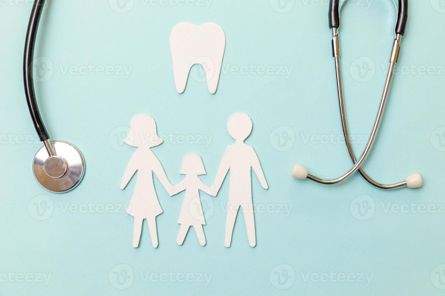 concept de soins dentaires de santé familiale. stéthoscope à plat modèle de symbole de découpe de famille de dents saines blanches isolé sur fond bleu. vérifier par l'enfant médecin dentiste. journée du dentiste en hygiène bucco-dentaire photo