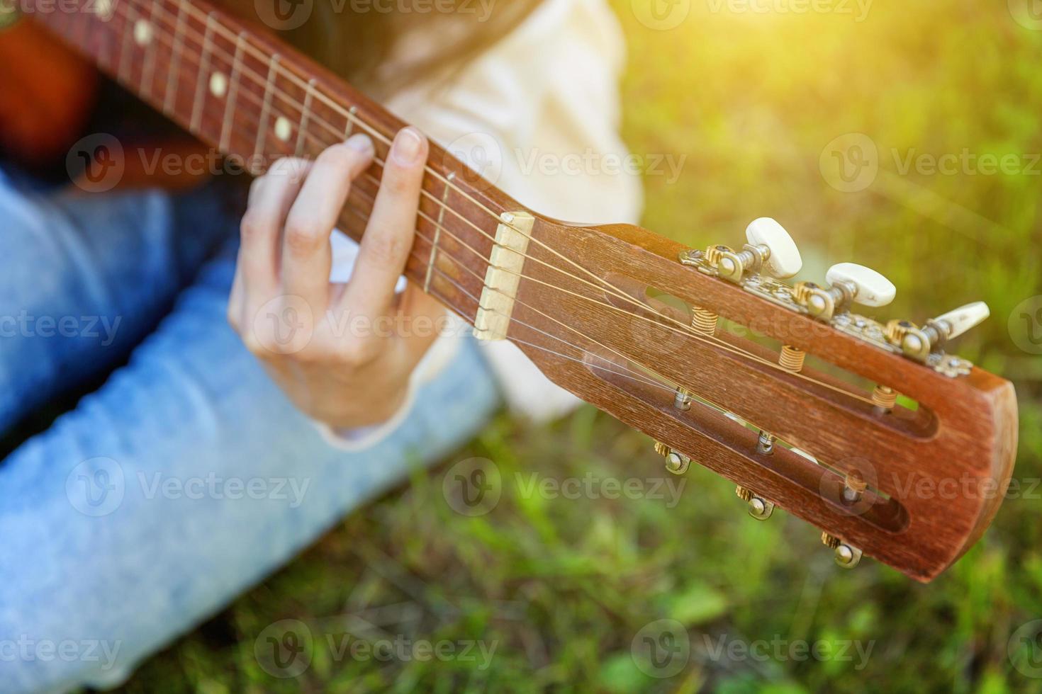 mains de femme jouant de la guitare acoustique photo