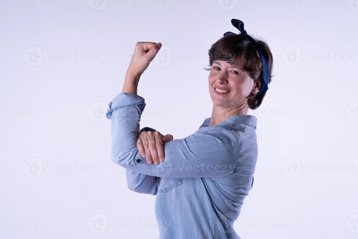 fille aux cheveux courts montrant un muscle du bras fort isolé. photo