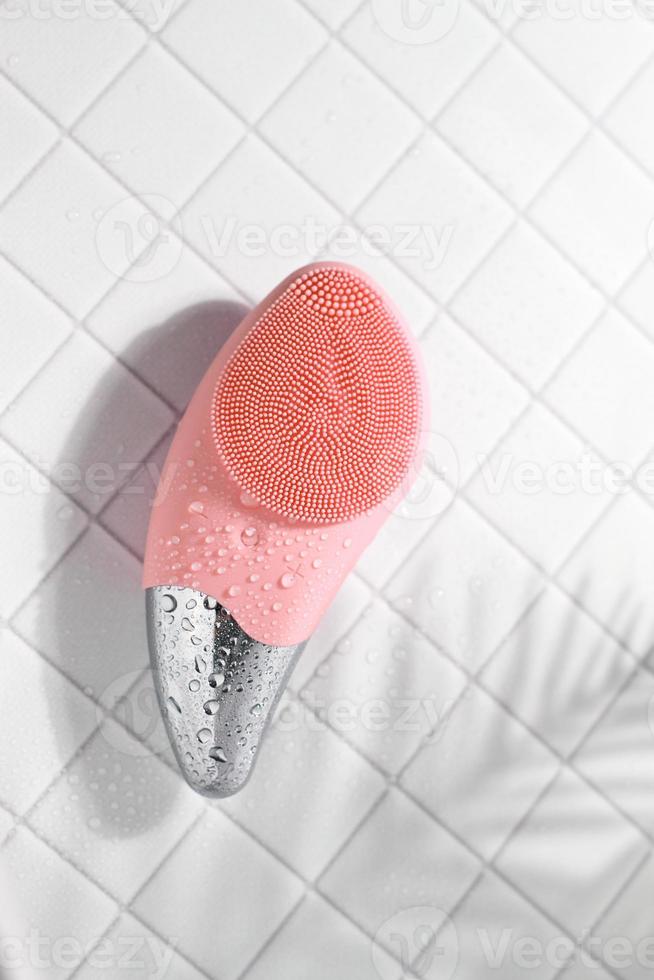 brosse sonique faciale pêche pour massage sur carrelage avec gouttes d'eau photo