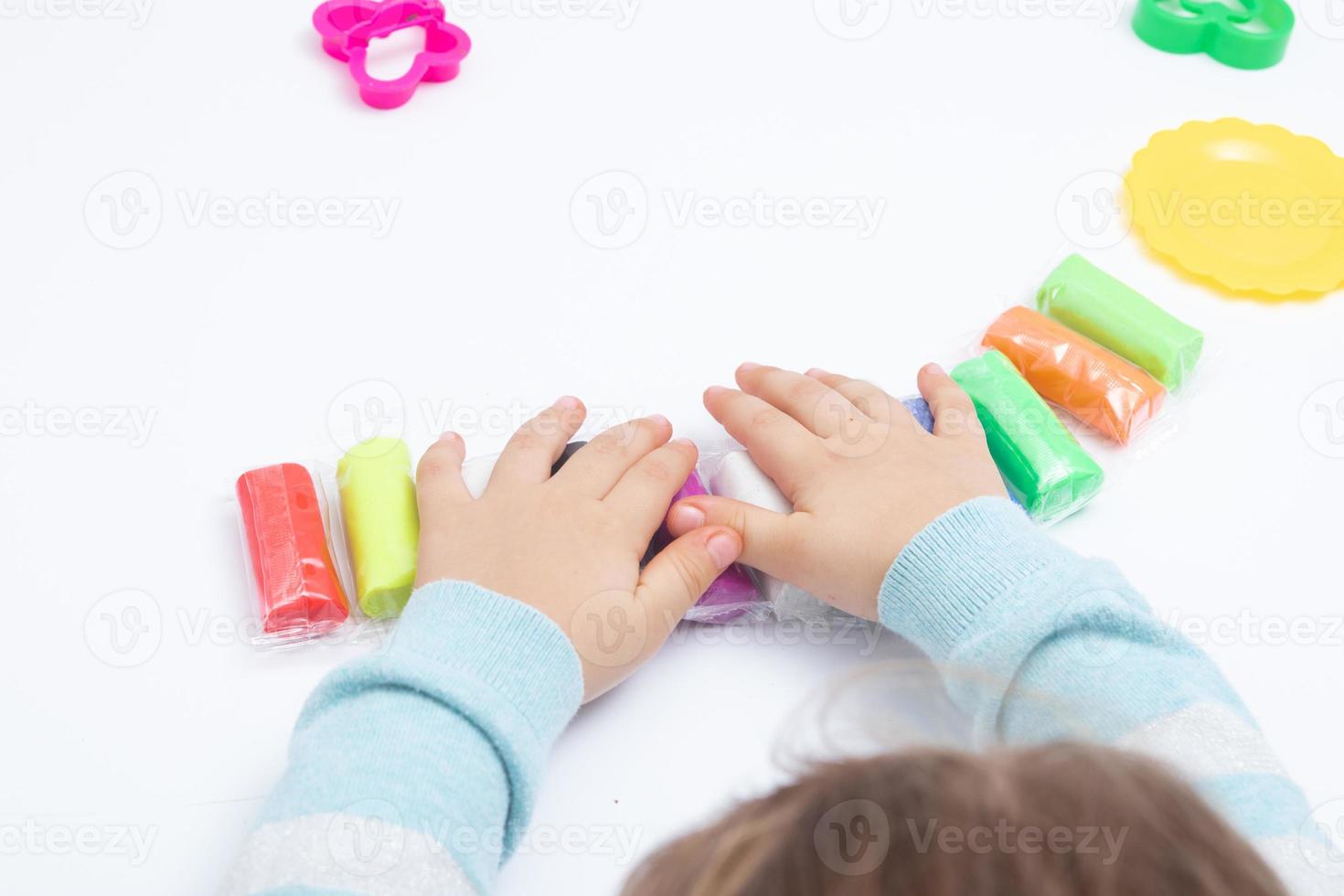 les mains des enfants jouent de la pâte pour la créativité des enfants. jeu de société pour le développement de la motricité fine photo