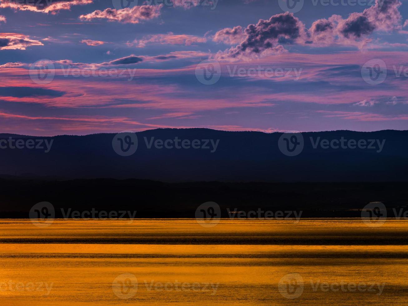 les magnifiques couleurs du coucher de soleil sur le lac Léman, le reflet du soleil couchant dans l'eau, l'atmosphère de paix et de tranquillité photo