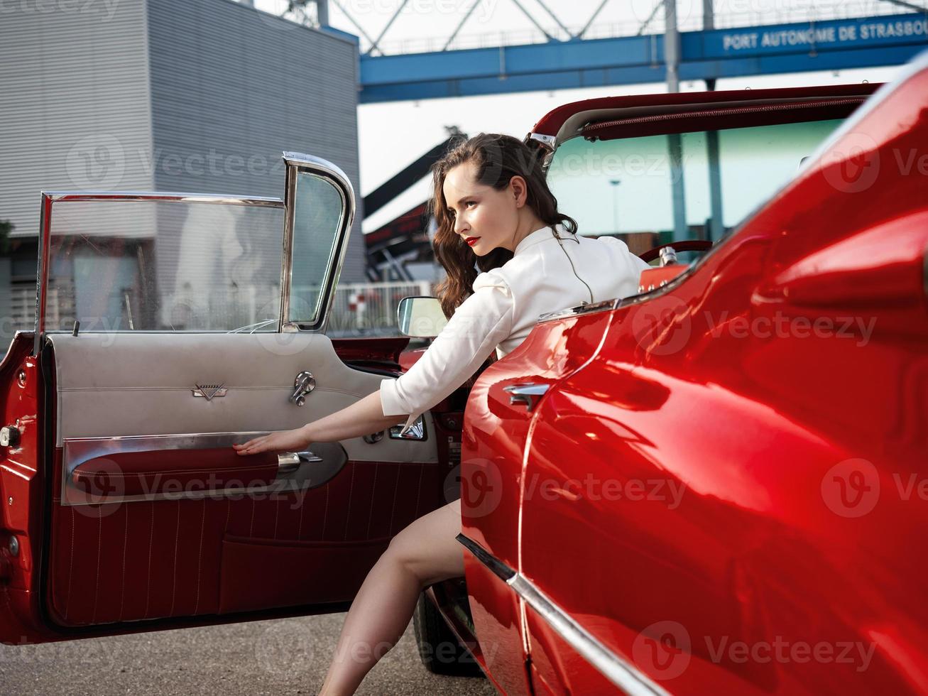 Cadillac rouge oldtimer des années 60 et une belle jeune fille photo