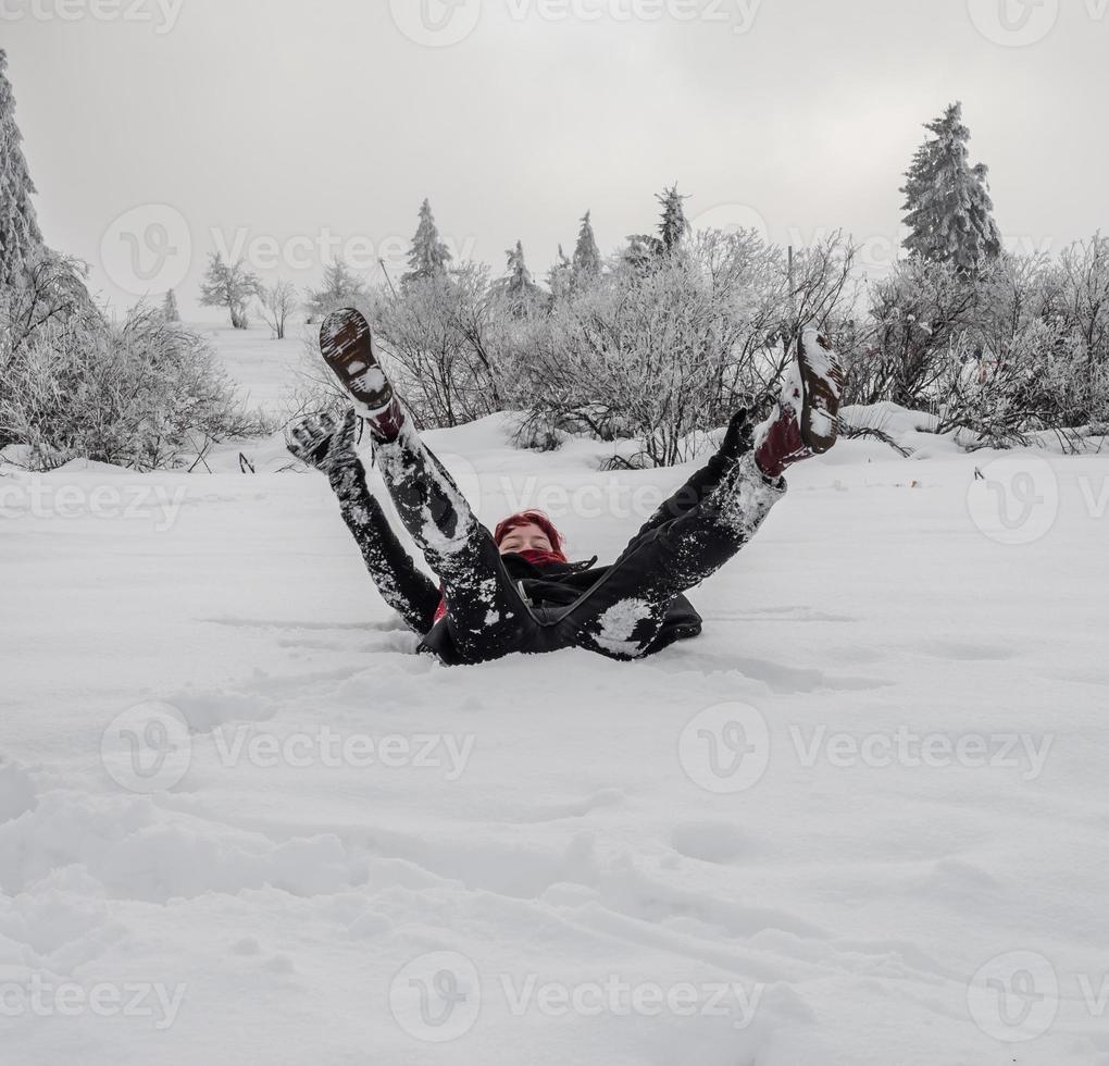 deux filles, soeurs, jouent avec un chien corgi sur un champ enneigé dans les montagnes photo