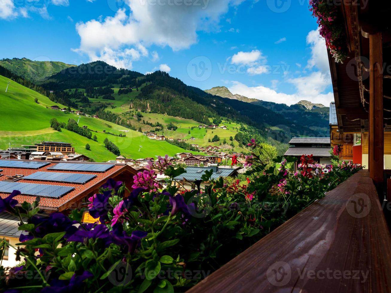 collines verdoyantes d'une station alpine en autriche en été. petit village, hôtels et chalets, tout en couleurs. belles terrasses et panneaux solaires sur les toits. la proximité de la civilisation et de la nature pure. photo