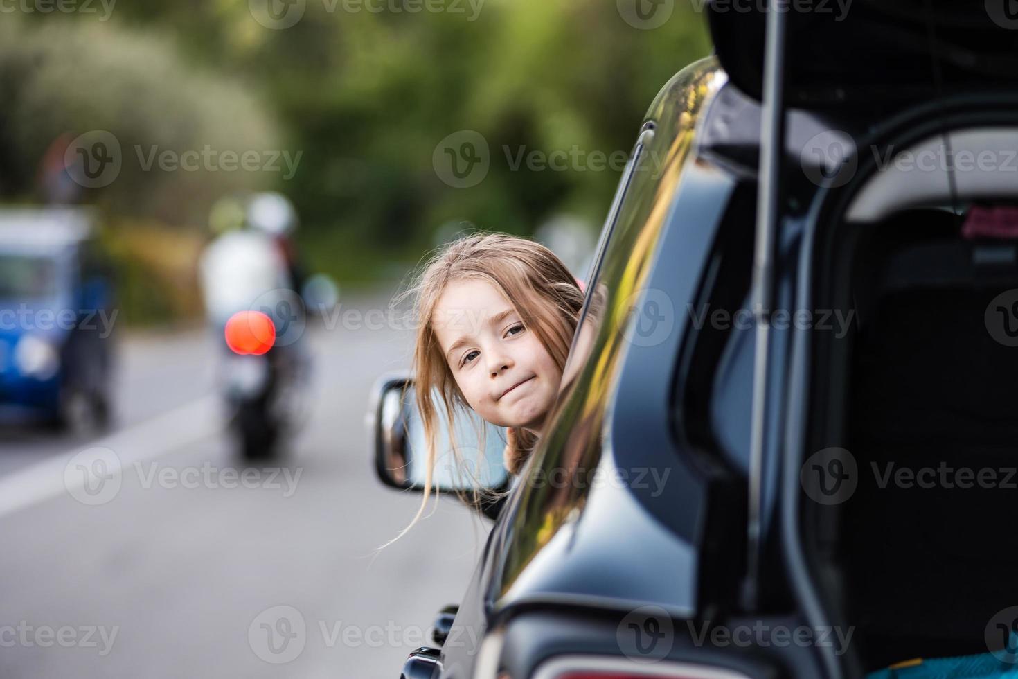 petite fille drôle grimace, penchée par la fenêtre de la voiture. voyage en  famille en voiture en europe. 5460204 Photo de stock chez Vecteezy