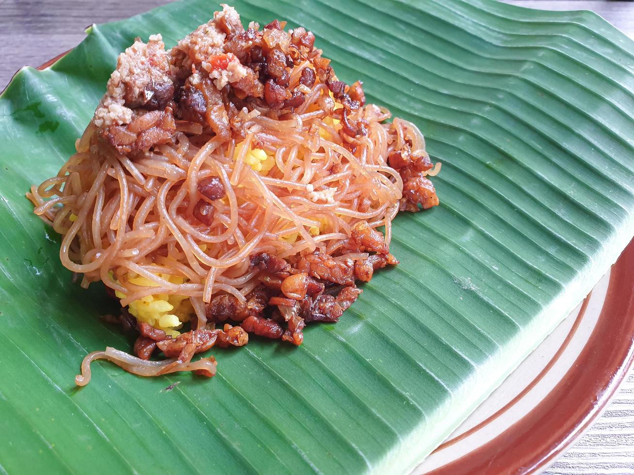 nasi kuning est un plat traditionnel indonésien, servi sur une feuille de bananier et une assiette photo