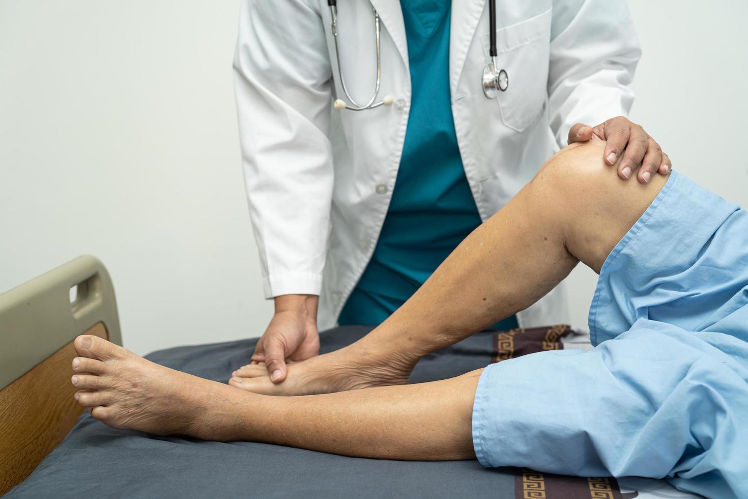 médecin asiatique physiothérapeute examinant, massant et traitant le genou et la jambe d'un patient âgé dans un hôpital d'infirmière de clinique médicale orthopédiste. photo