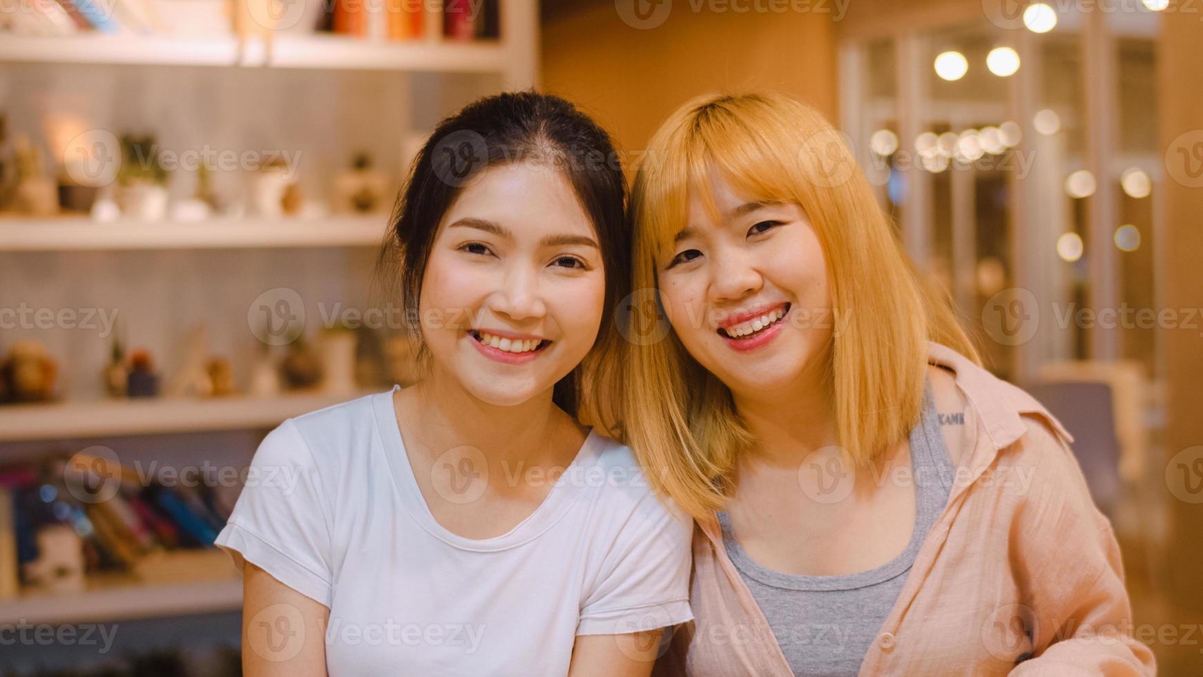 portrait de femmes chinoises asiatiques se sentant heureuses souriantes dans la bibliothèque de l'université. jeune fille d'amis de premier cycle se détendre sourire à pleines dents en regardant la caméra sur le campus universitaire des heures supplémentaires au concept de nuit. photo