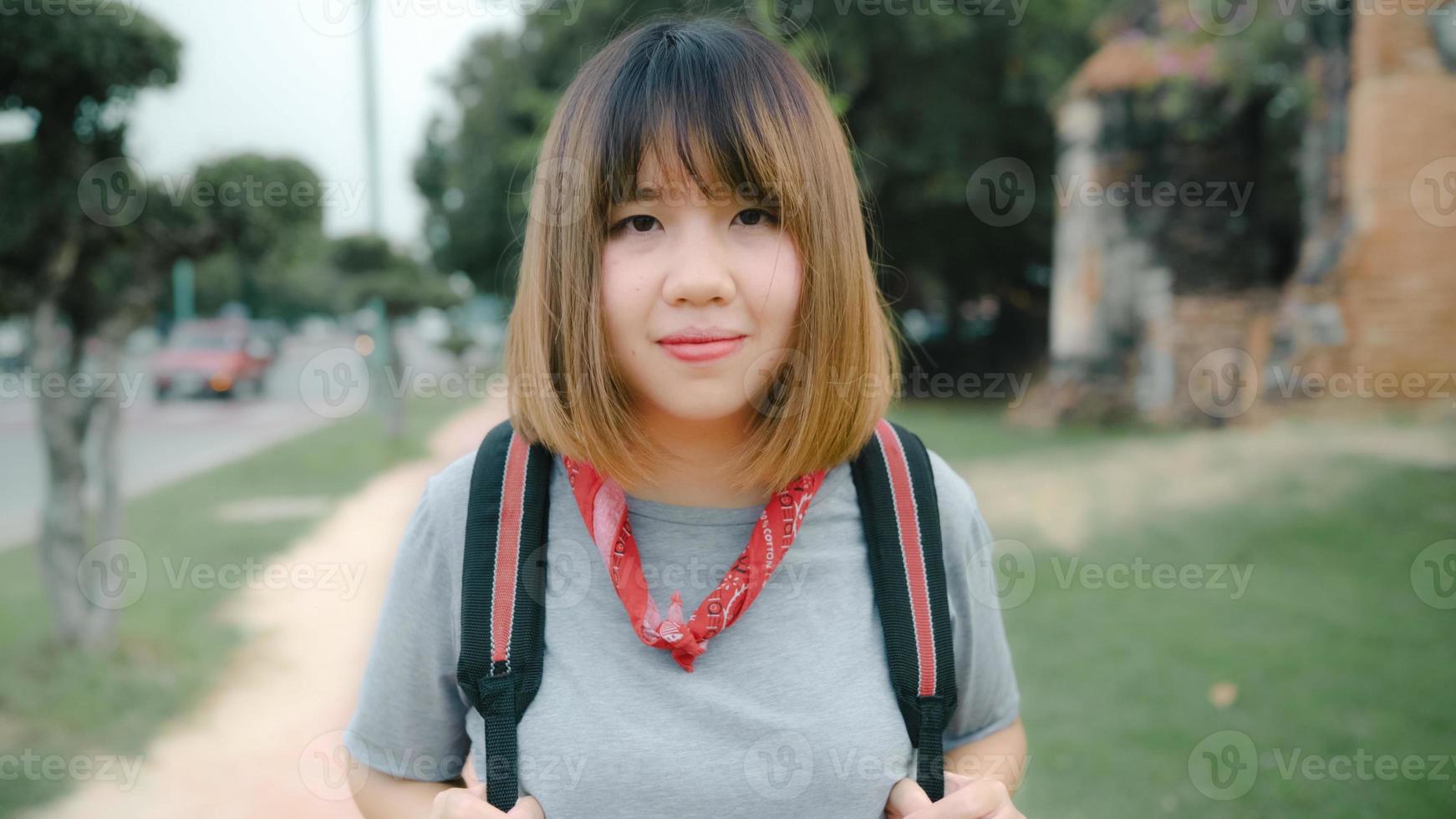 femme asiatique voyageuse se sentant heureuse souriante à un voyage de vacances avec caméra à ayutthaya, thaïlande, femme routarde profite de son voyage dans un point de repère incroyable dans la ville traditionnelle. concept de vacances de voyage de style de vie photo