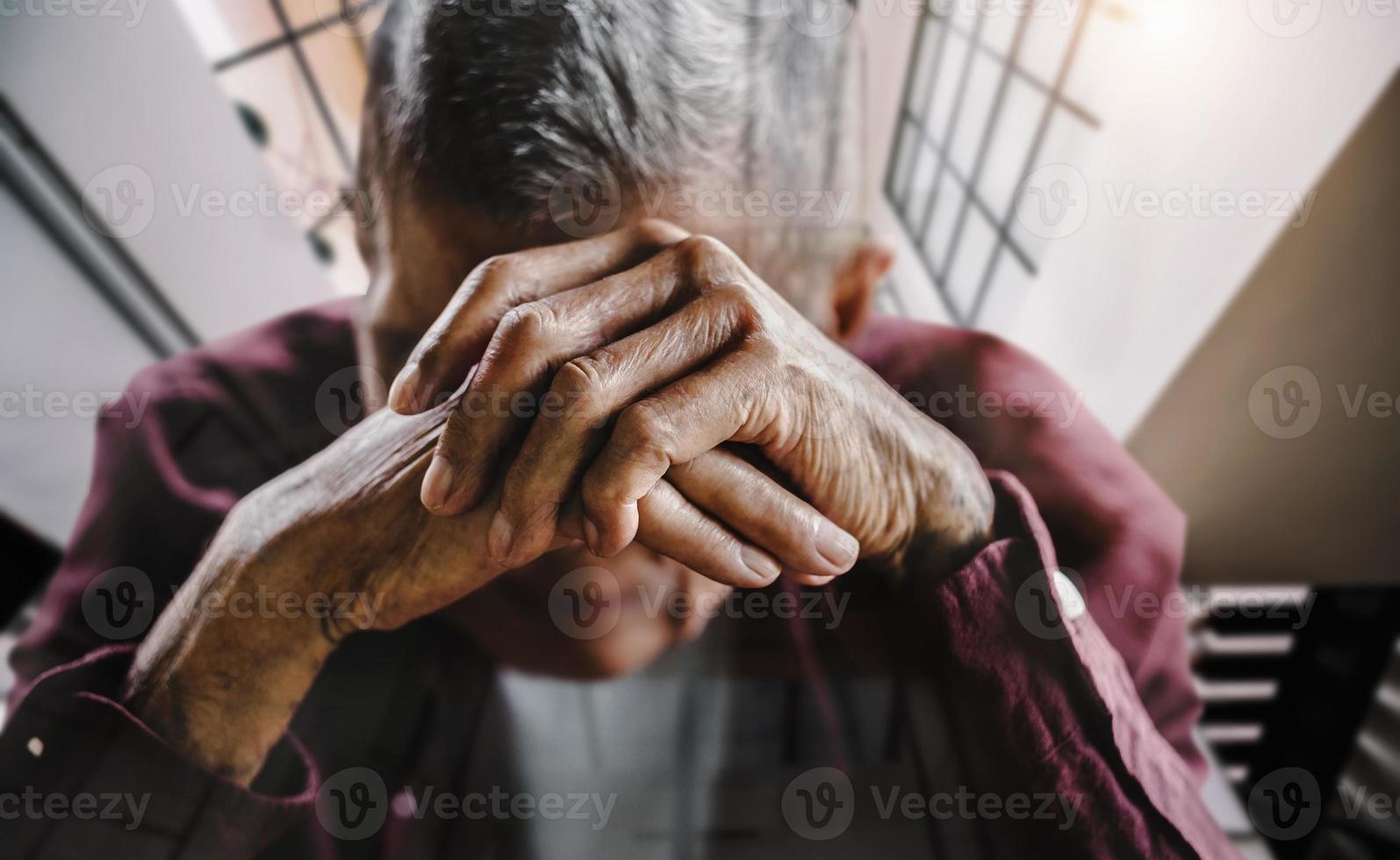 homme senior couvrant son visage avec ses mains. photo