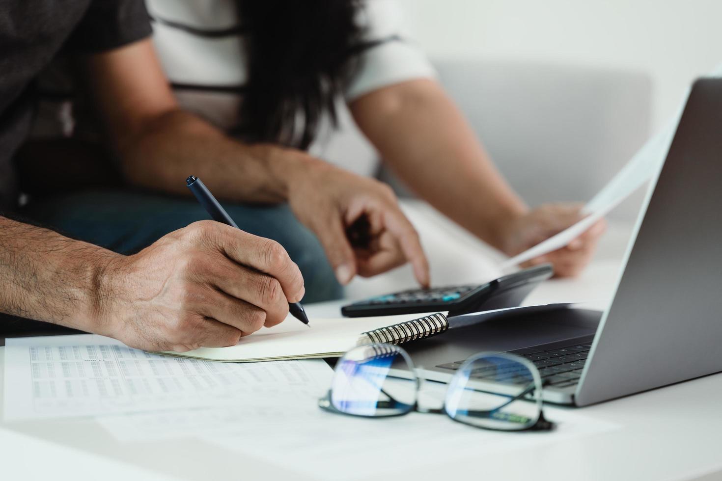 l'homme et la femme calculent l'impôt annuel avec une calculatrice et remplissent le formulaire de déclaration de revenus des particuliers. saison pour payer le concept de planification fiscale et budgétaire. photo