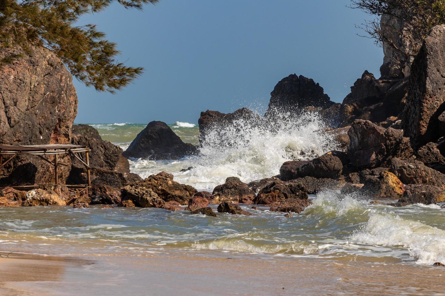 les vagues et les forts vents marins ont balayé les rochers et les hauts-fonds. les vagues et les brises marines s'écrasent contre les rochers et les rivages. photo