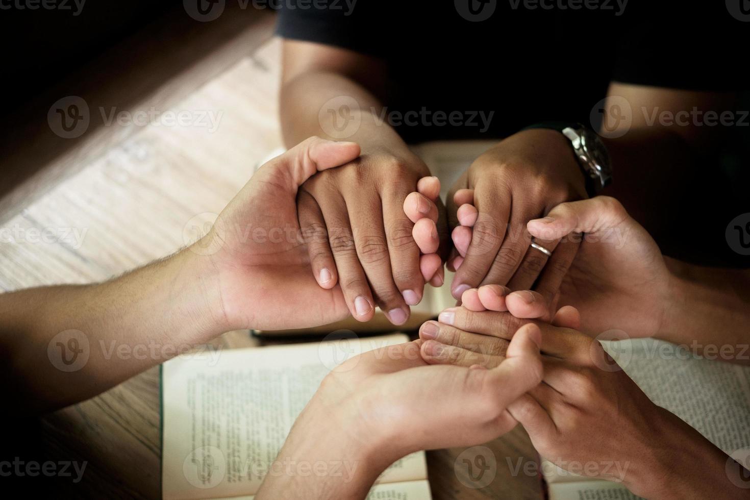 les chrétiens sont des fidèles qui se donnent la main pour prier et rechercher les bénédictions de dieu. concept de réunion de dévotion ou de prière. photo
