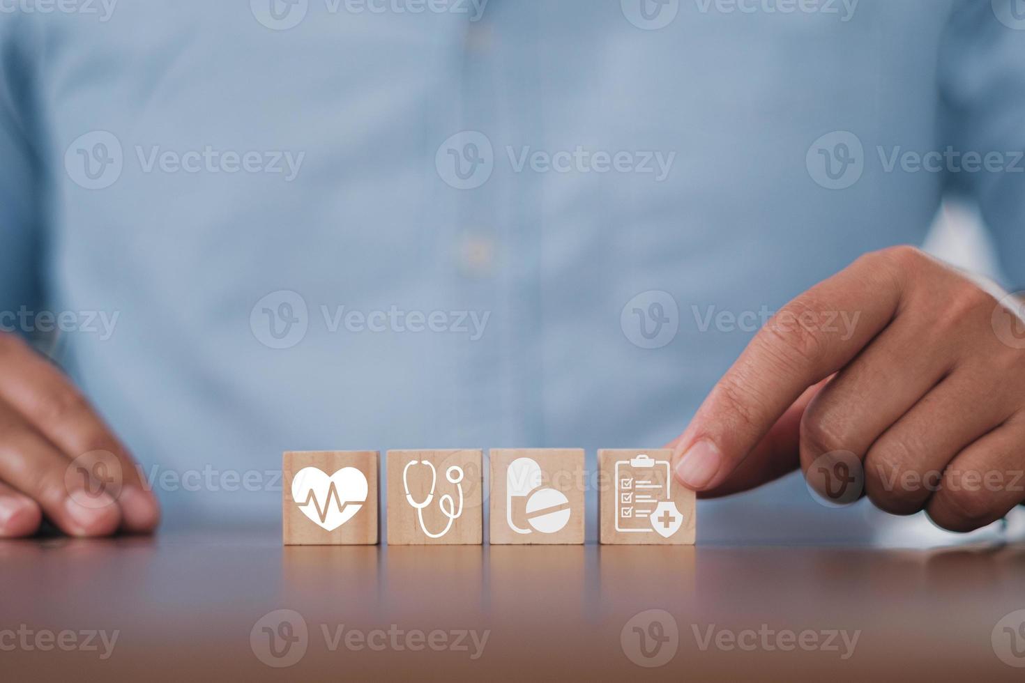 main d'homme organisant l'empilement de blocs de bois avec l'icône médicale de soins de santé. assurance maladie - concept de santé photo