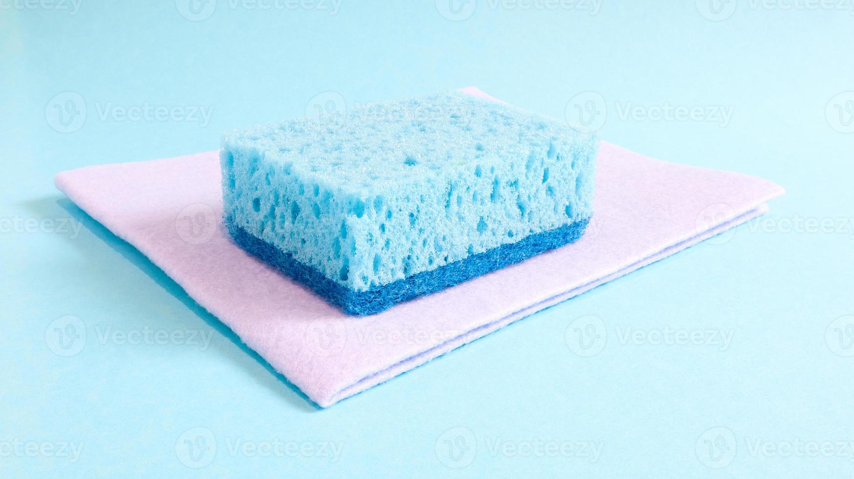 une éponge bleue utilisée pour laver et effacer les salissures utilisées par les ménagères au quotidien. ils sont réalisés en matériau poreux tel que de la mousse. rétention de détergent, ce qui vous permet de le dépenser économiquement photo