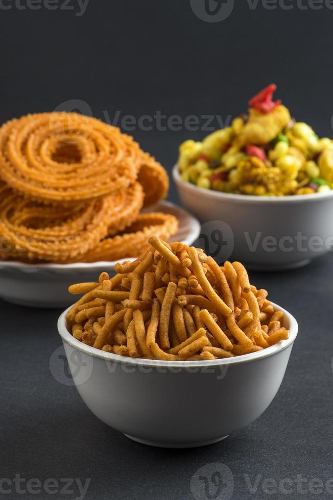 snack indien chakli, chakali ou murukku et farine de gramme besan sev et chivada ou chiwada. nourriture de diwali photo