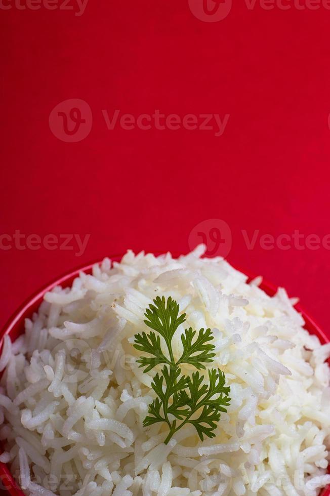 riz basmati blanc ordinaire cuit dans un bol rouge sur fond rouge photo
