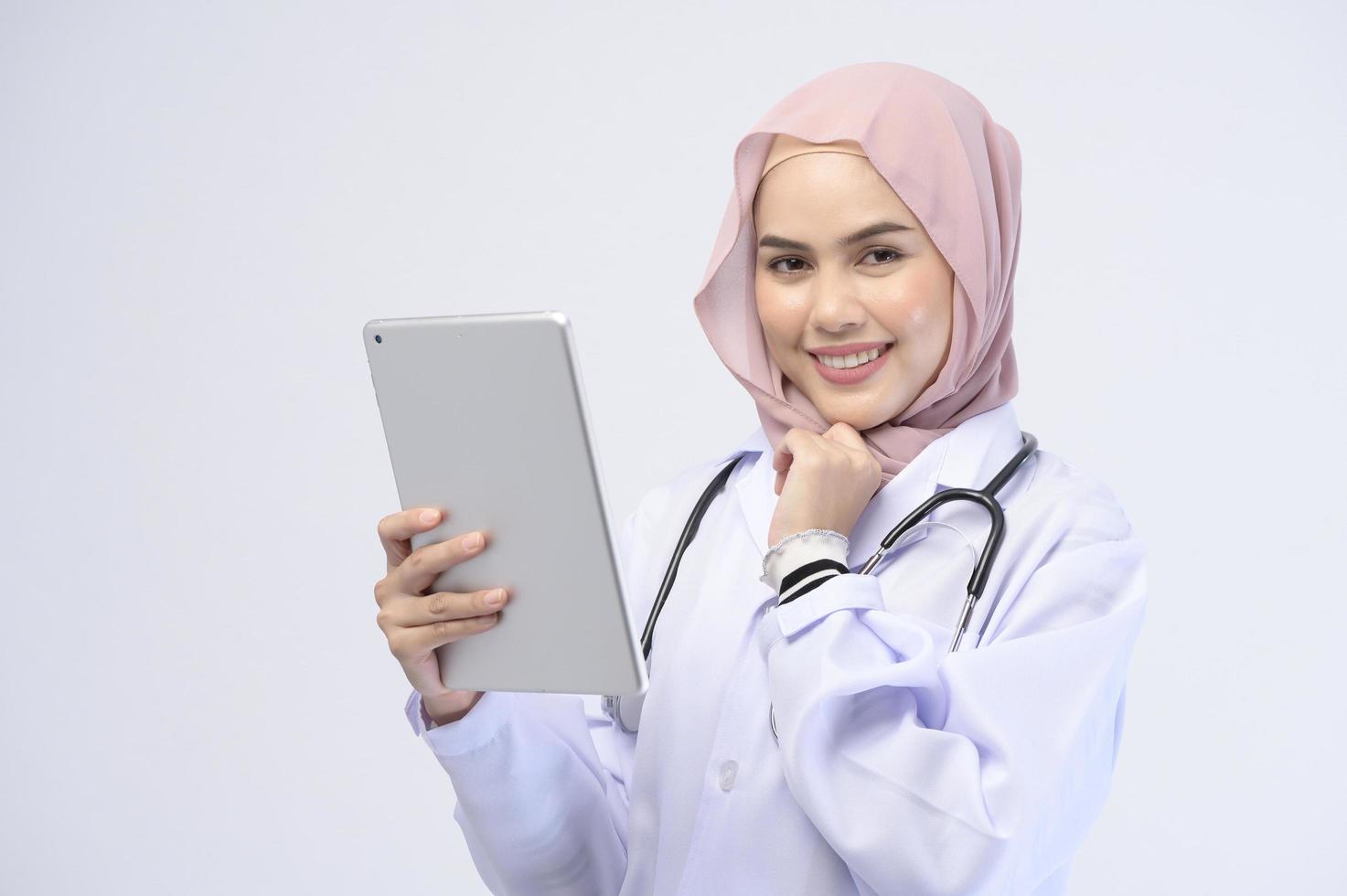 femme médecin musulmane avec hijab sur fond blanc studio. photo