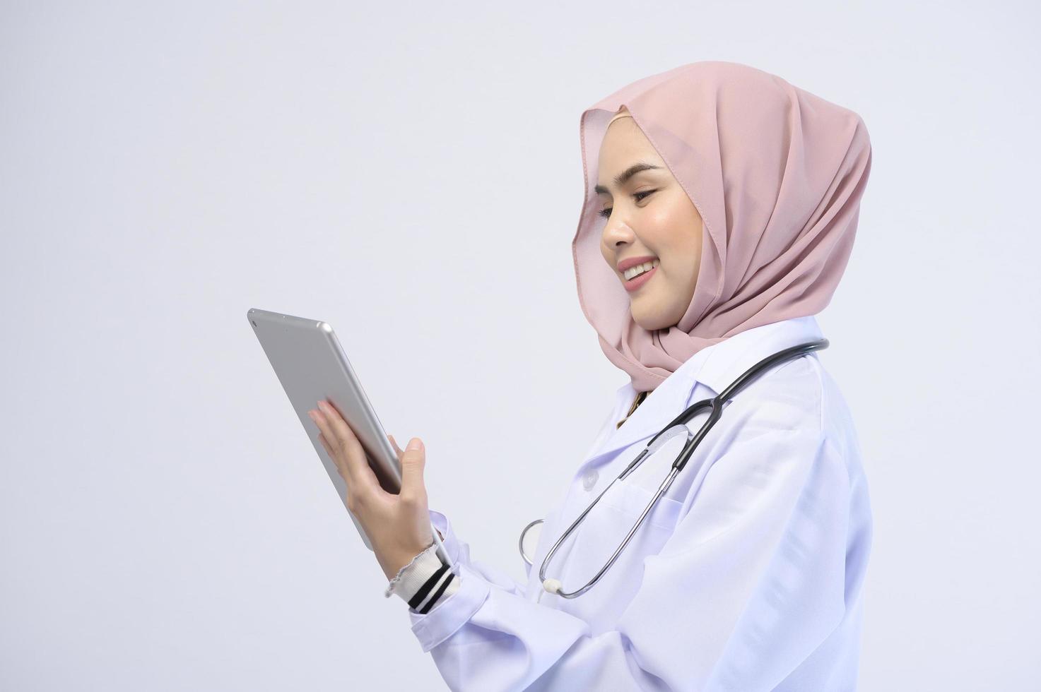 femme médecin musulmane avec hijab sur fond blanc studio. photo