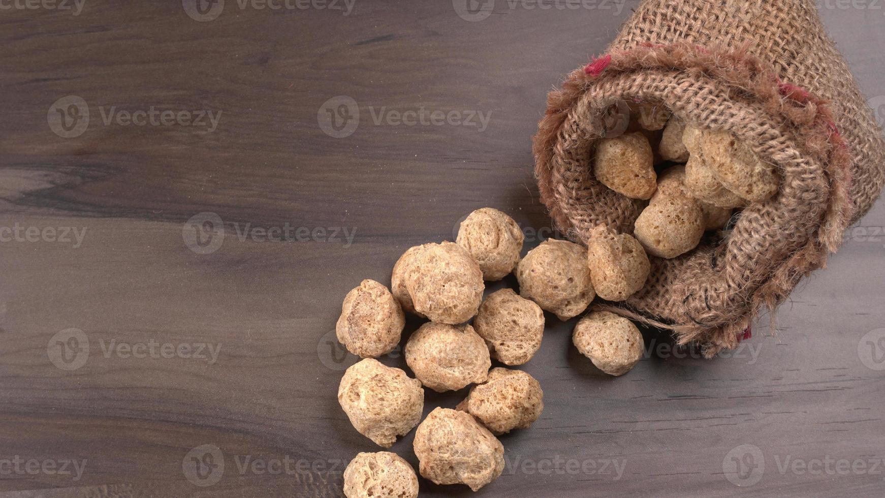 morceaux de soja crus sur fond sombre. viande de soja saine et nutritive, morceaux isolés. concept de nourriture végétalienne. photo