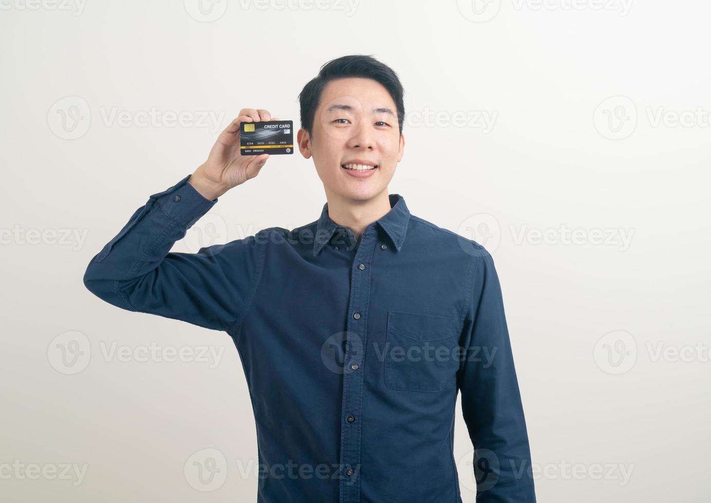 jeune homme asiatique tenant une carte de crédit photo