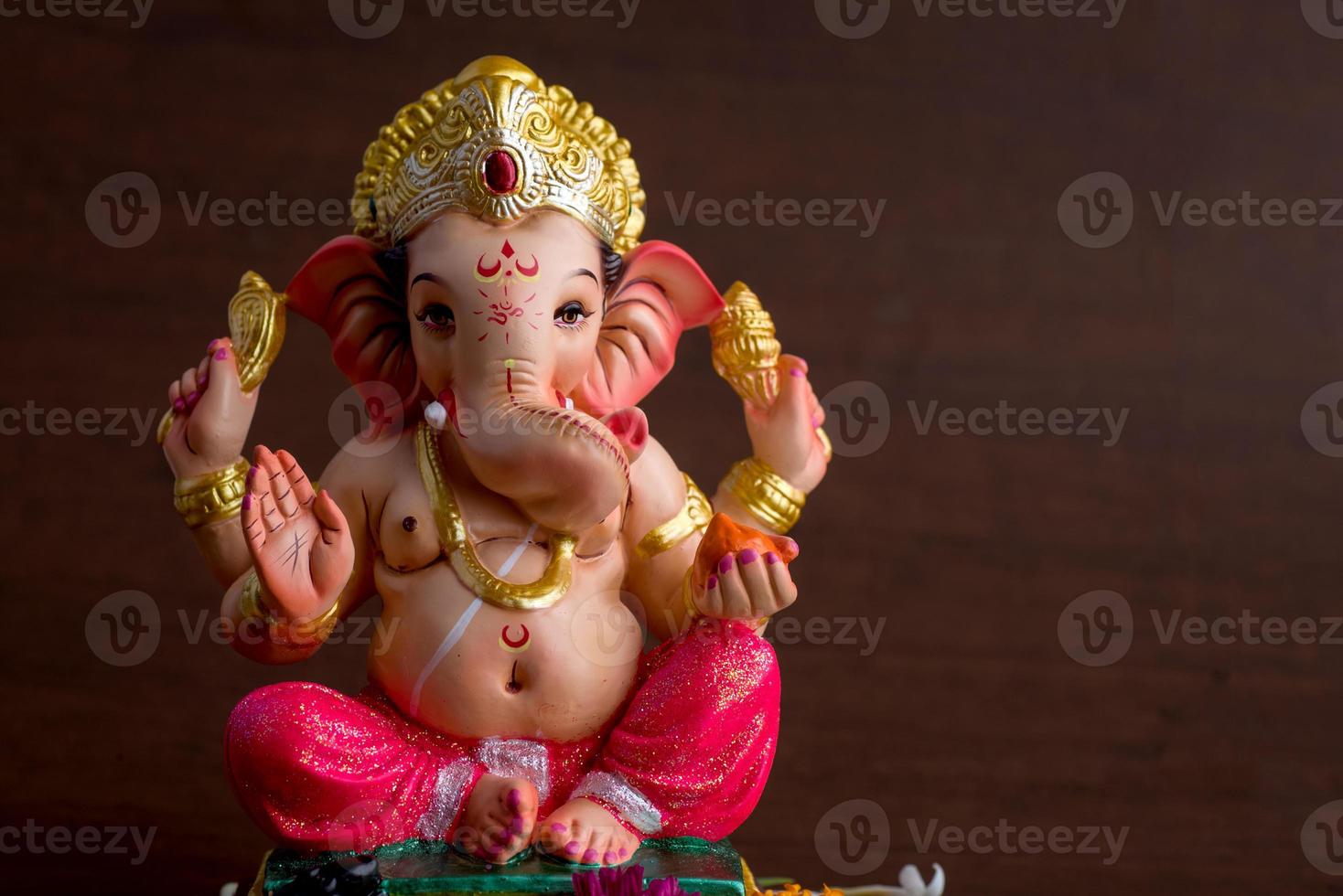 dieu hindou ganesha. idole de ganesha sur fond de bois foncé. photo