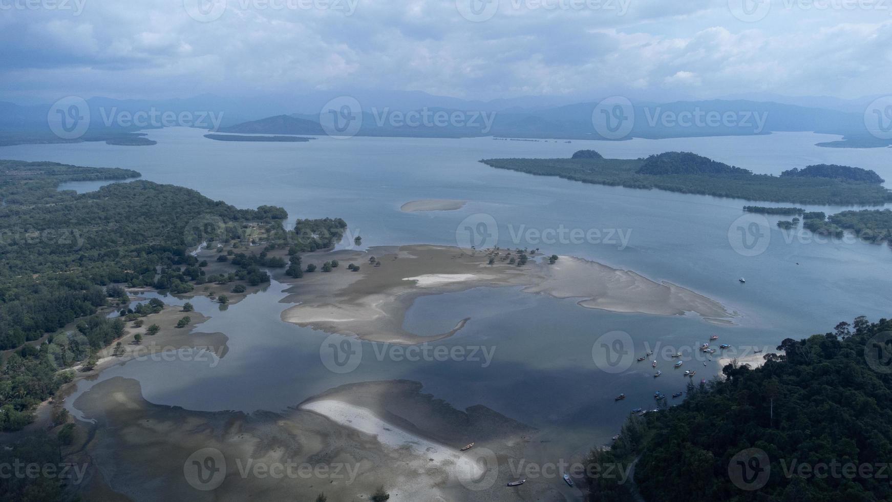 belle mer au parc national de laem son, ranong, thaïlande. dans la zone du port de pêche local et en arrière-plan de la belle côte de la nature par vue aérienne depuis un drone. photo