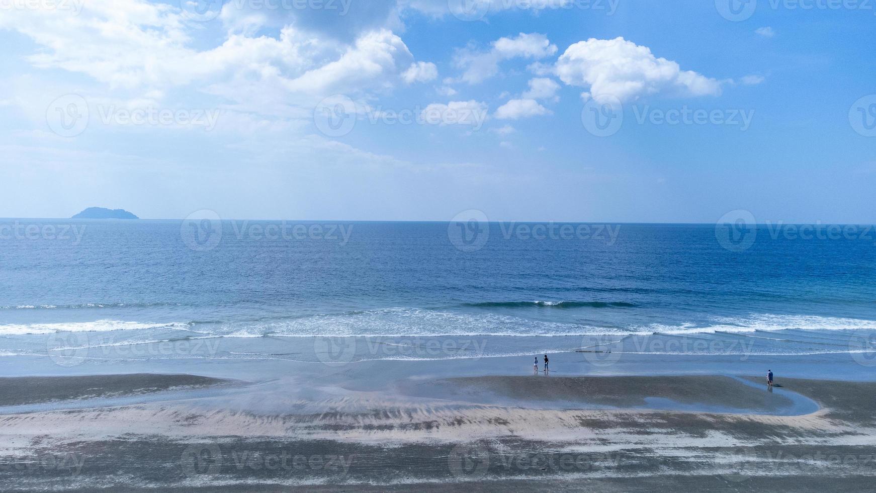 mouvement de la vague douce et de l'océan bleu sur fond de plage de sable noir. plage de sable noir dans le parc national de laem son à ranong, thaïlande photo