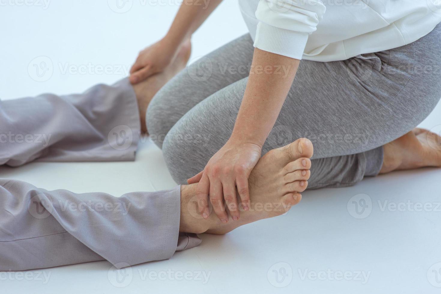 mains faisant un massage thaïlandais des pieds à un homme. médecine alternative et concept de massage thaïlandais photo