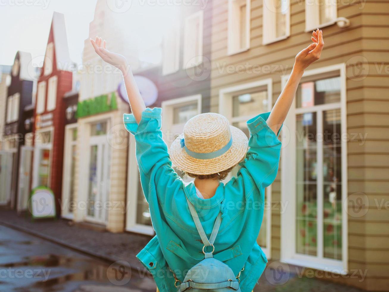 dos de jeune femme rousse au chapeau de paille et avec sac de voyage avec carte papier voyage en europe de l'ouest. photo de voyage et lifestyle