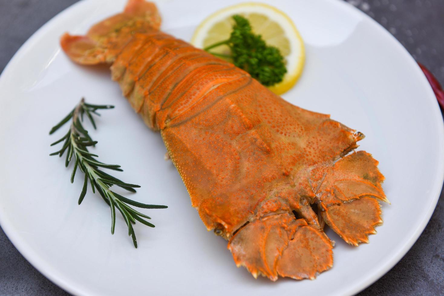 Crevettes de homard à tête plate servies sur une assiette blanche, langouste fraîche bouillie à tête plate avec persil citron romarin dans le restaurant de fruits de mer, homard de roche moreton bay bug photo