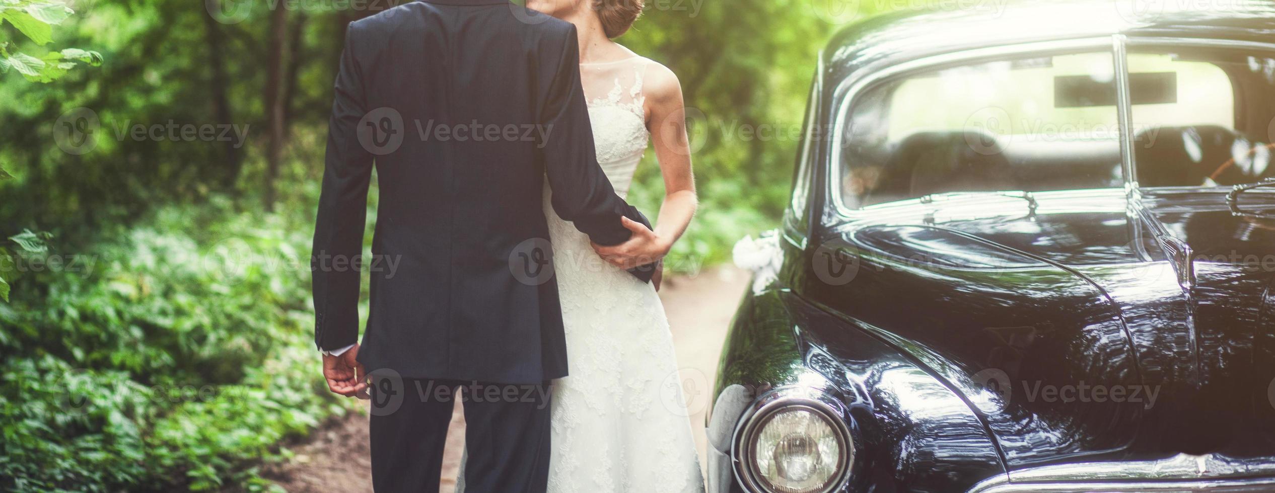 couple embrassant près de voiture rétro photo