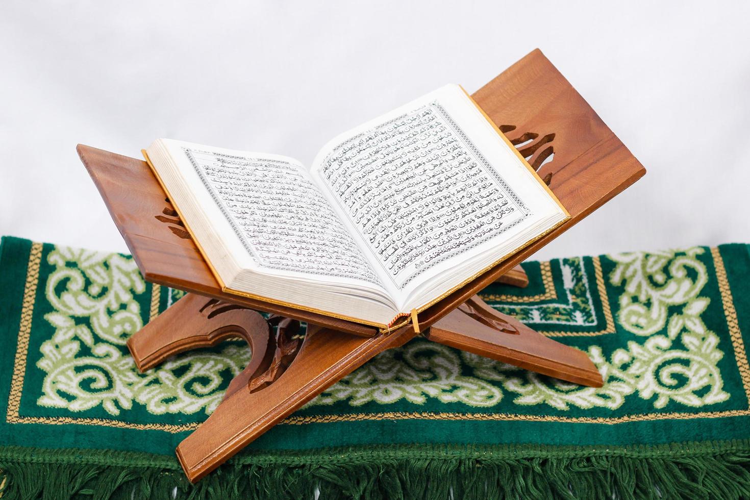 Le livre saint al coran et tapis de prière isolé sur fond blanc photo