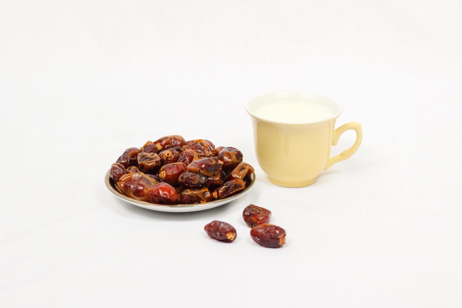 dates et un verre de lait isolé sur fond blanc photo