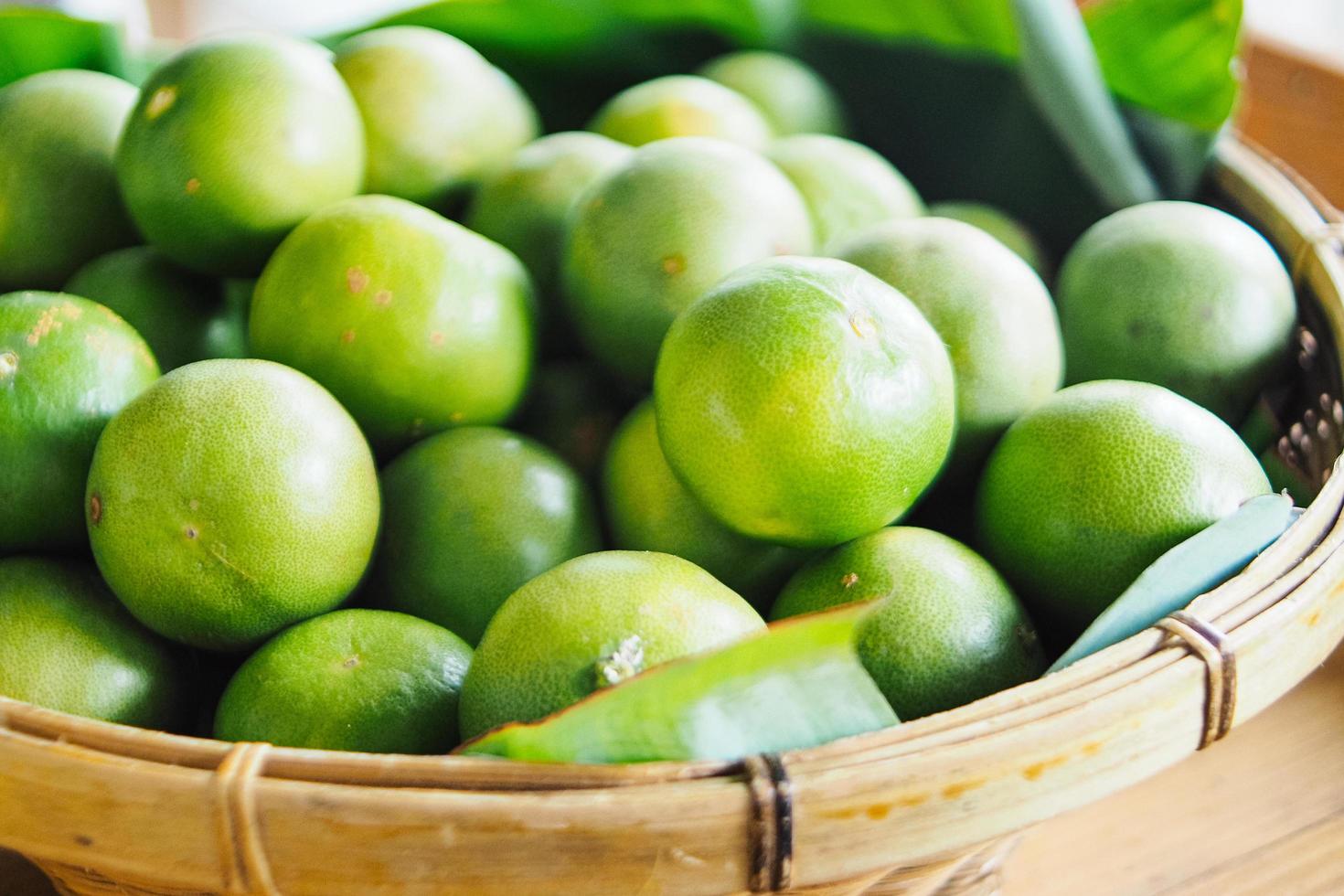 citrons verts dans un panier tressé dans un marché agricole de l'industrie de l'agriculture. photo